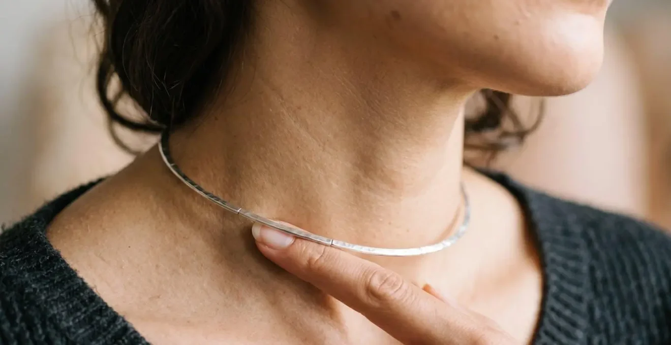 Nahaufnahme einer Frau die den Sitz eines Colliers am Hals prüft